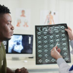 doctor explaining cause of back pain e1699554786491