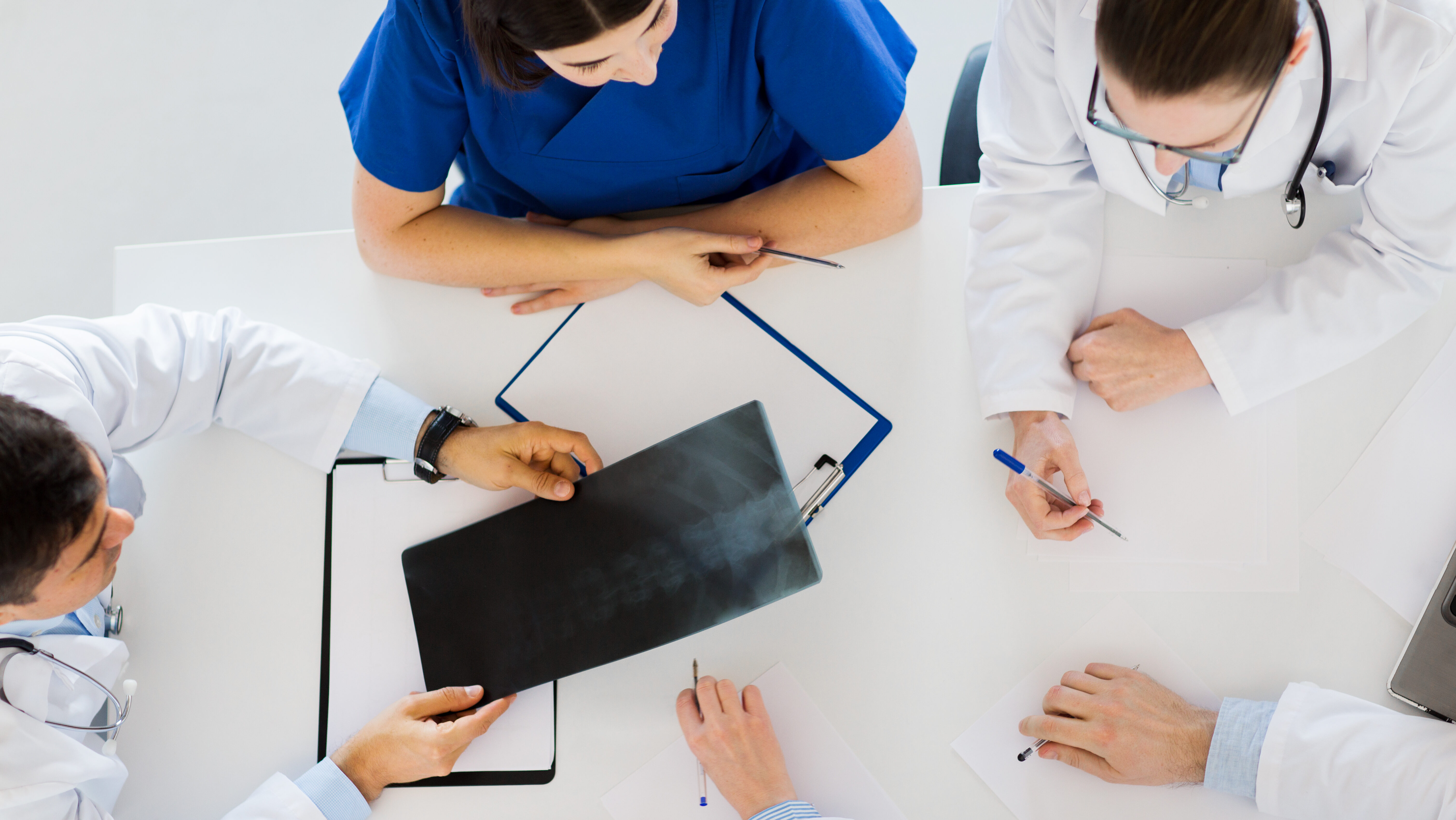 doctors with spine x ray and clipboards e1699543204947