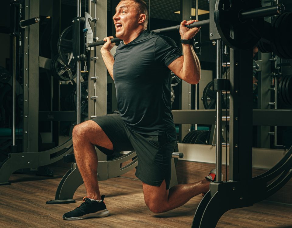 Hernie discale : Les erreurs courantes à éviter 14 Fit man doing squats in a training machine